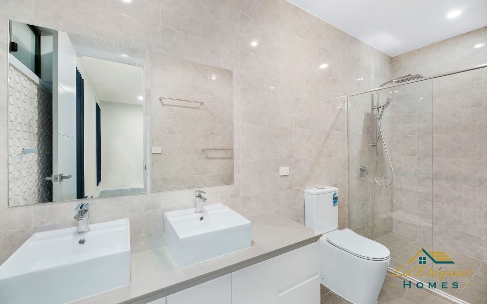 Bathroom with twin vessel basins, stone benchtop and a frameless walk-in shower
