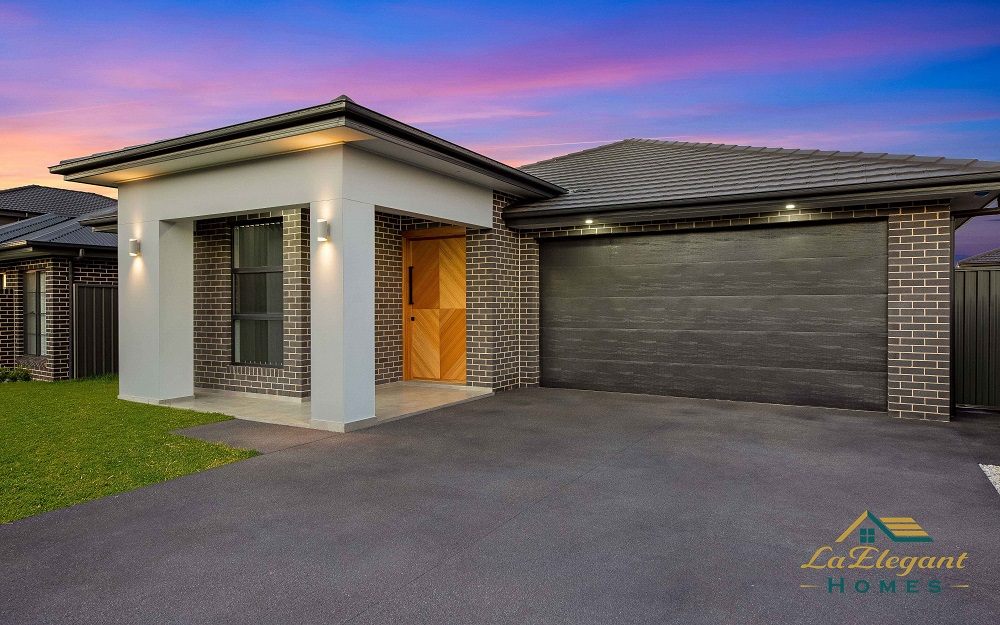 Completed home at dusk showing the driveway and garage