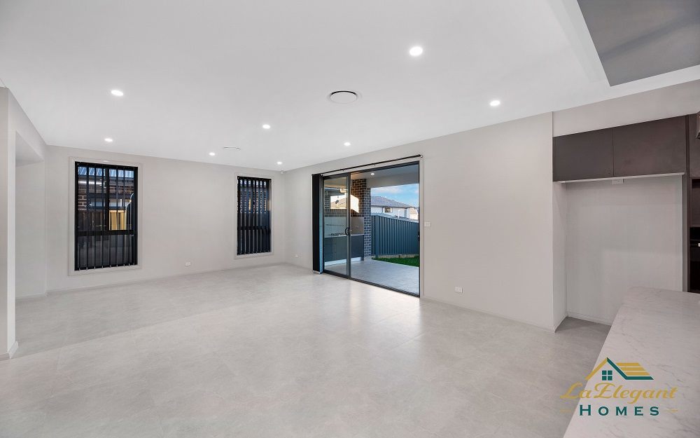 Open-plan living area with large-format tiled flooring and sliding doors opening to the alfresco