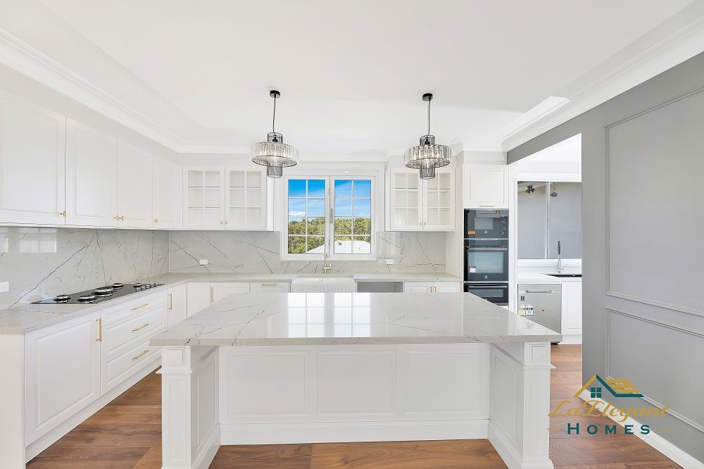 Kitchen with white shaker joinery and a marble-look stone island in a completed LA Elegant Homes build