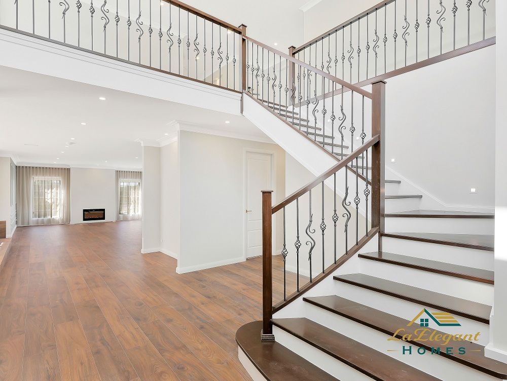 Timber and wrought-iron staircase rising through a double-height void in a completed Kellyville home