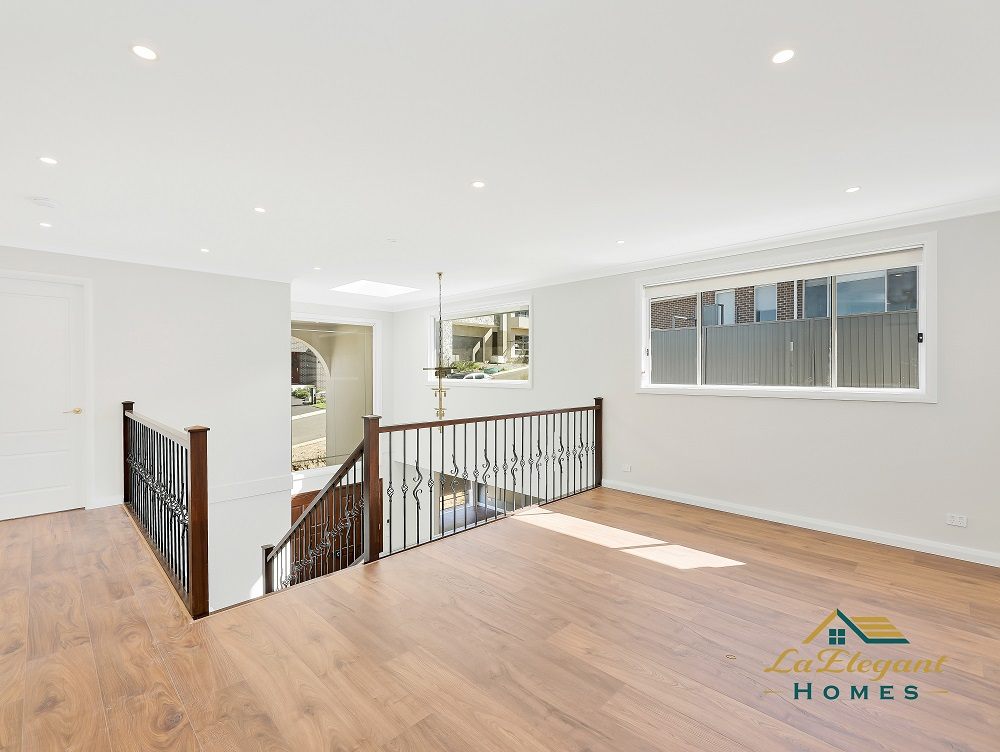 Upstairs living area overlooking the entry void, with timber flooring and a wrought-iron balustrade